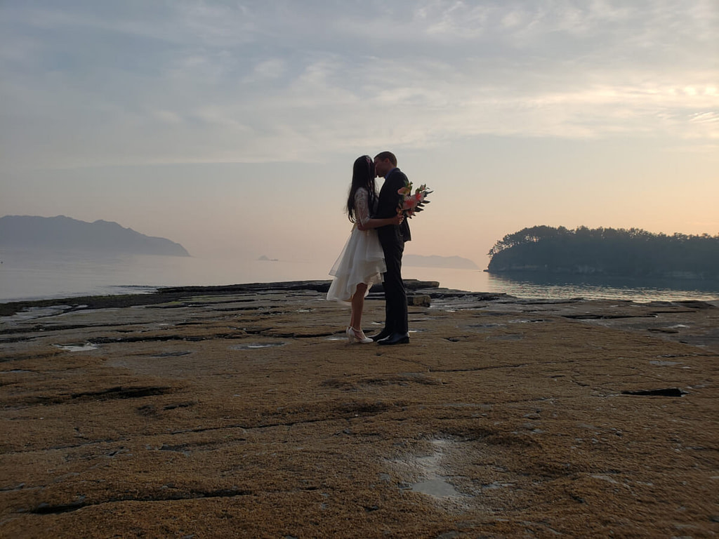 Wedding photo kissing on the rocks at sunset