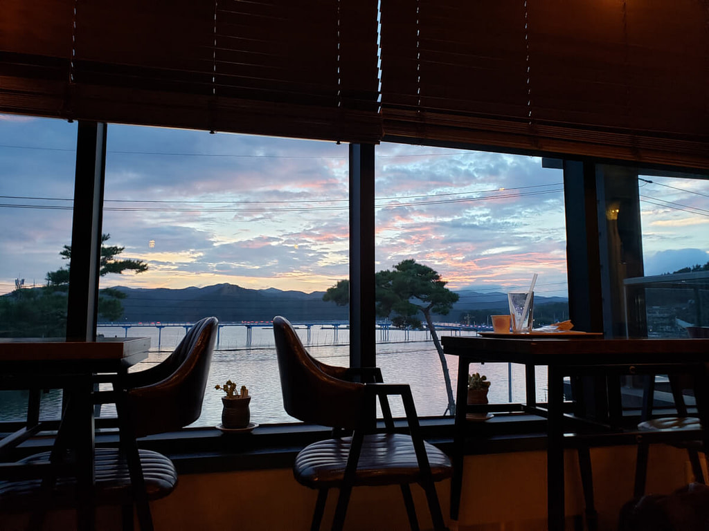 Sunset view over the water and mountains from inside café