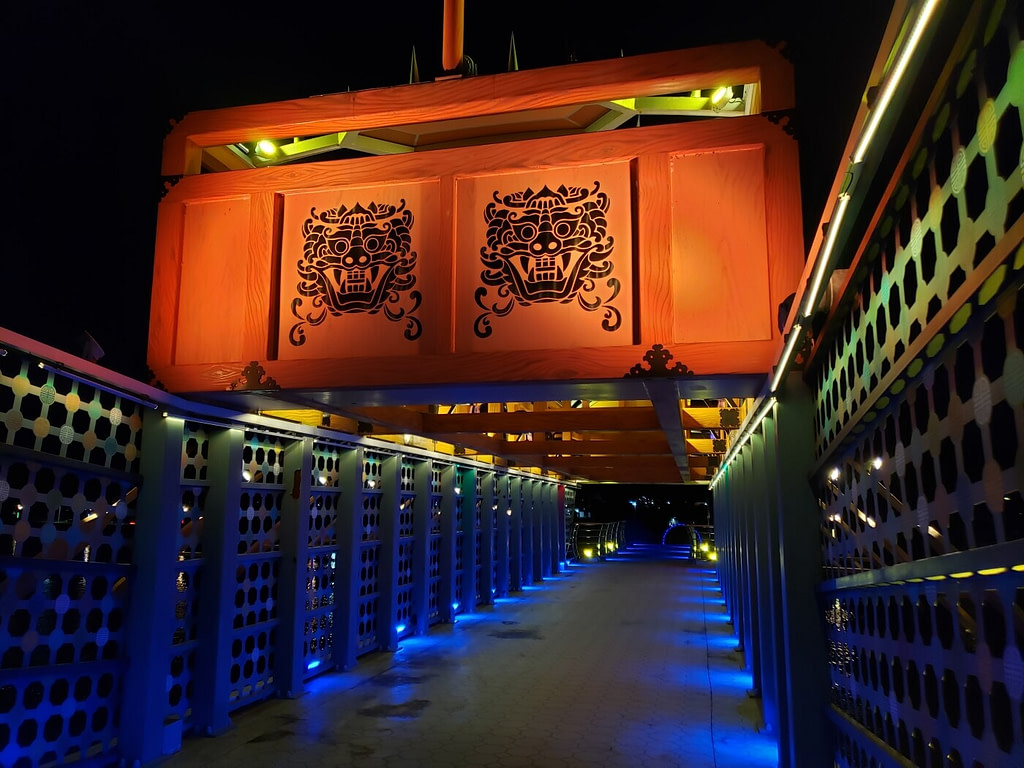 The rear of the turtle ship above a pedestrian bridge with two painted lion faces