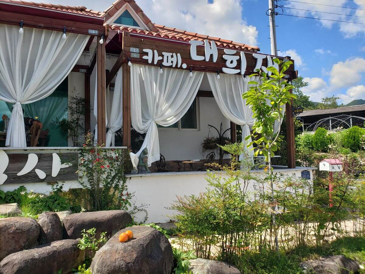 The front porch of Daehuijae Café with white curtains