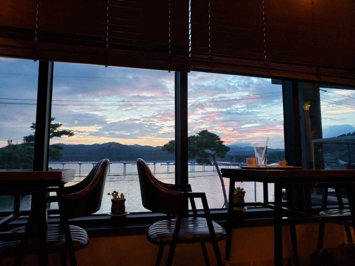 Sunset view over the water and mountains from inside café