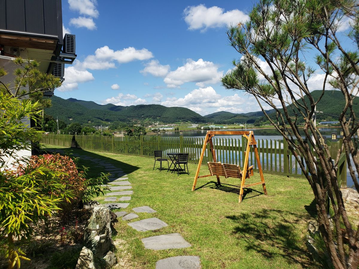 A swinging bench in the grassy yard of Daega Lake Café