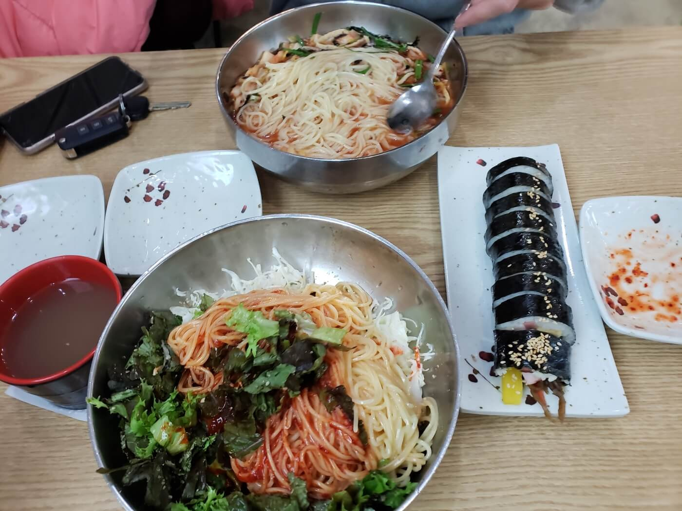 Bowls of bibim guksu and mul guksu after mixing