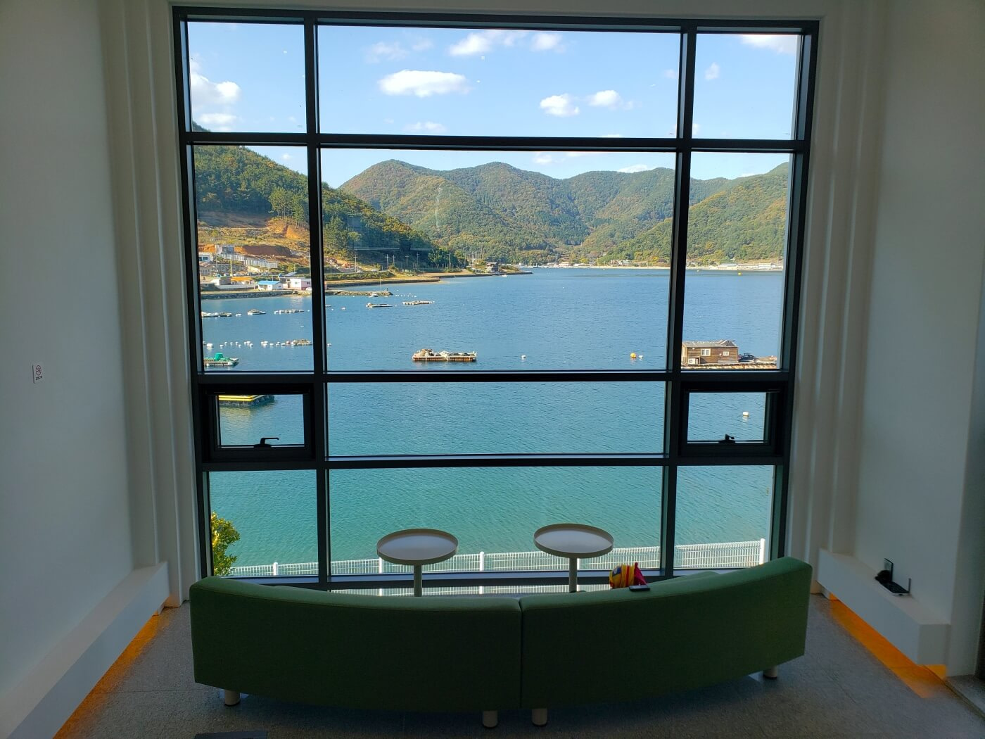 Large window at Nessun Dorma Café overlooking aqua sea and mountains in Goseong, South Korea