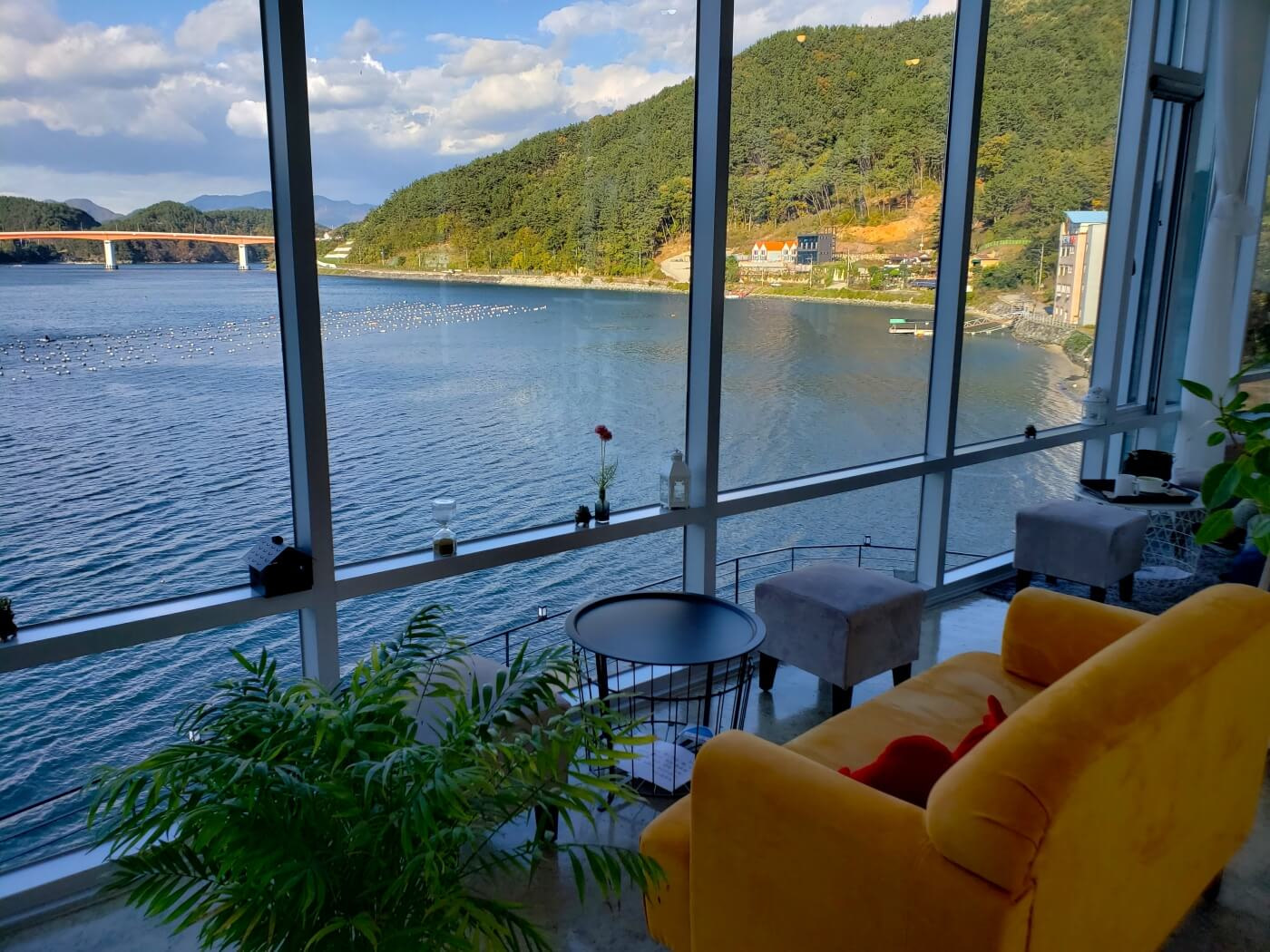 An orange couch on second floor overlooking the sea and mountains