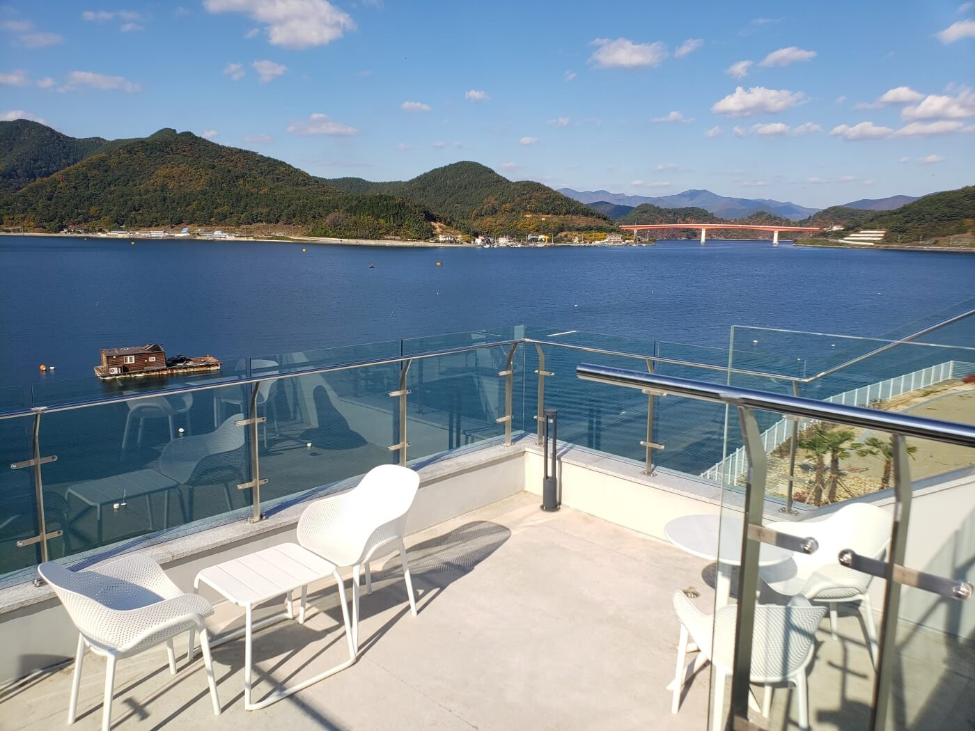 An orange bridge over the sea in the distance, viewed from the 3rd floor balcony of café Nessun Dorma in Goseong, Gyeongnam, Korea