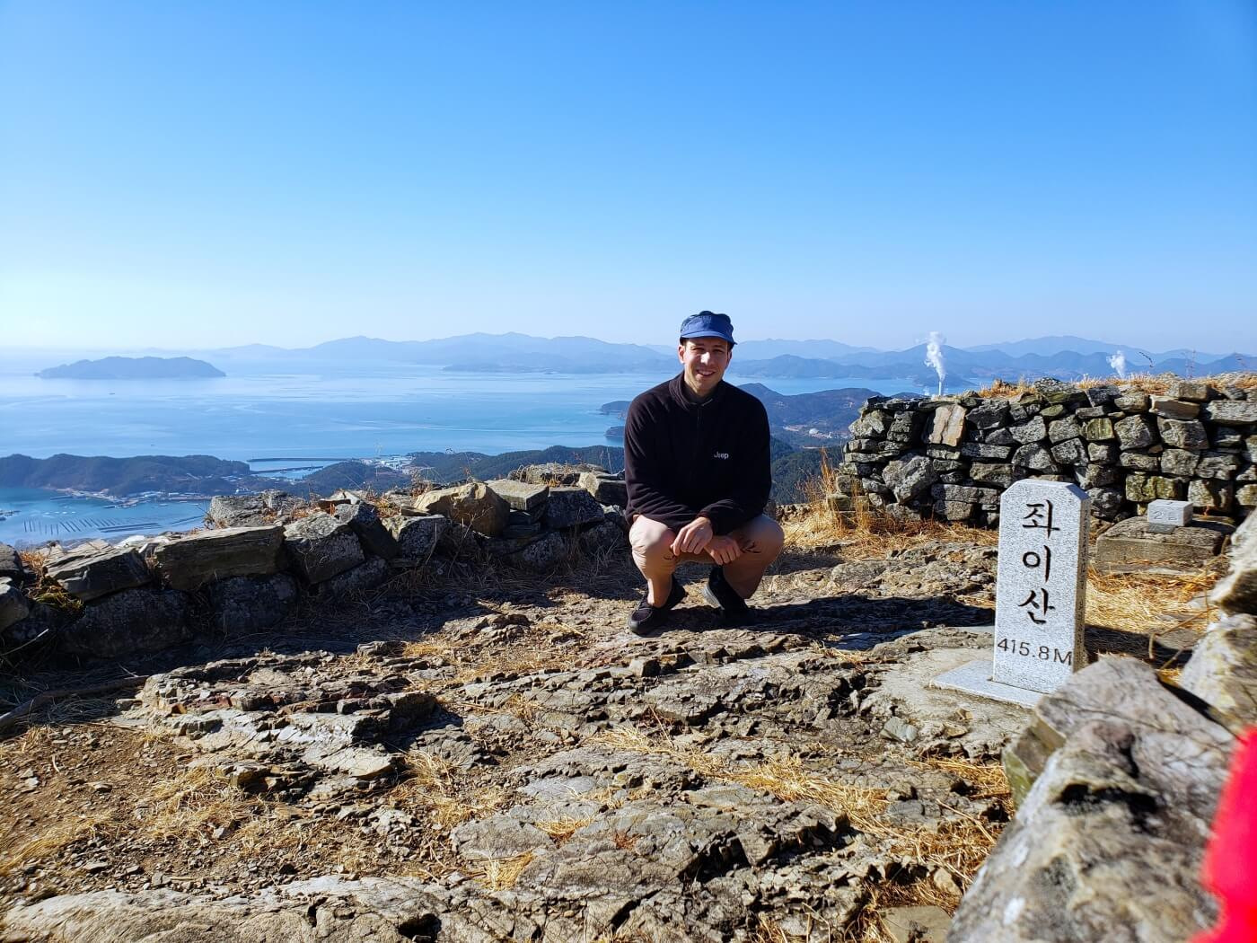 Nate crouching at the headstone of Jwaisan mountain