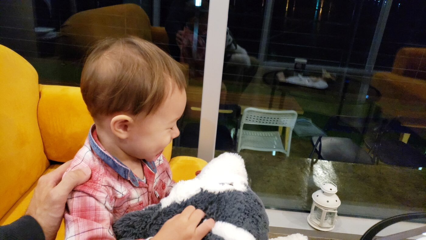 Baby Noah laughing with a stuffed animal