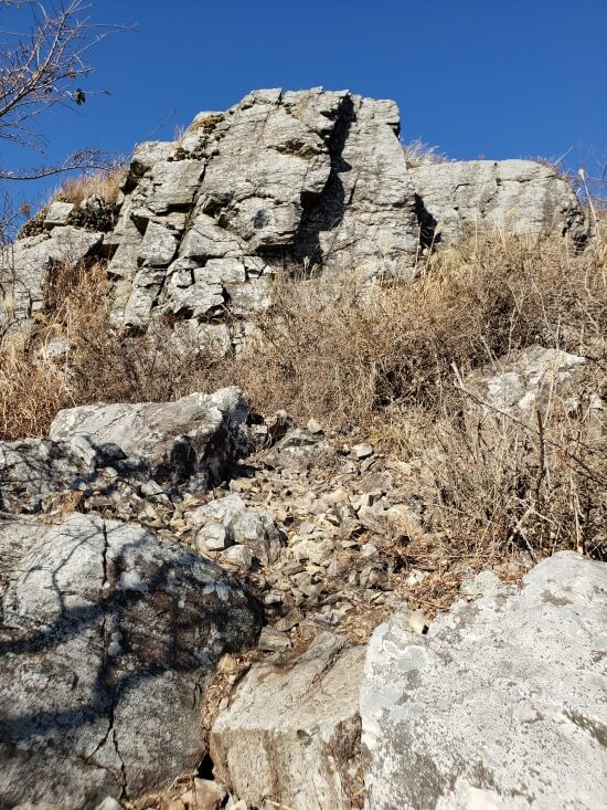 Brown grass and rocks around a mountain peak