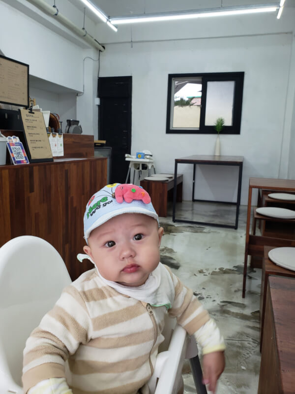Baby Noah sitting inside with a hat