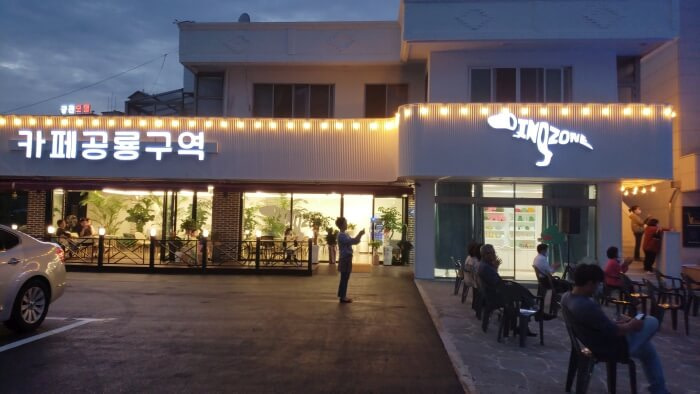 People sitting outside at a café watching performers
