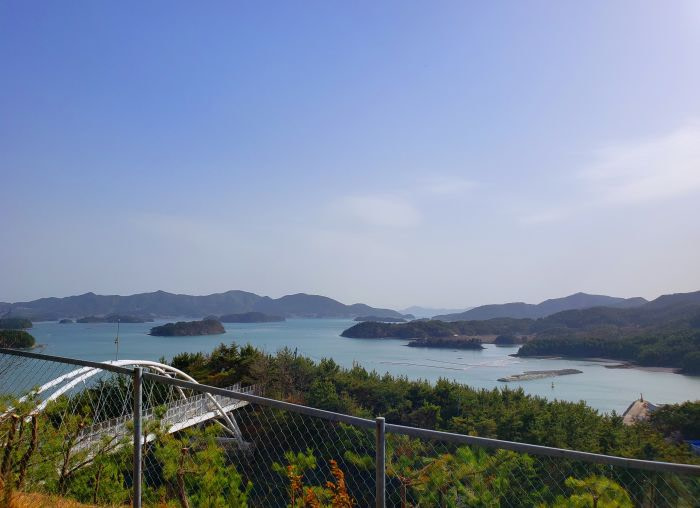 View of a white bridge across a highway near islands in the sea
