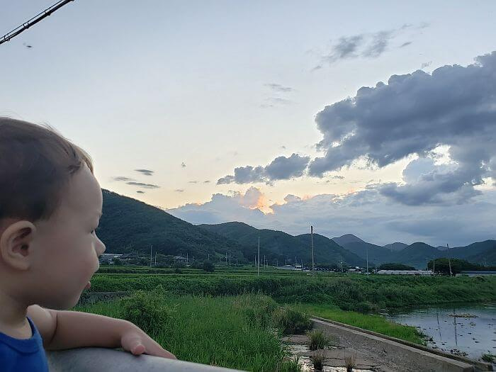 Noah looking out across the stream and mountainous countryside