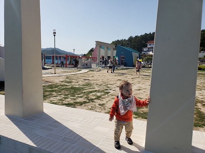 Baby Noah standing by a pillar outside