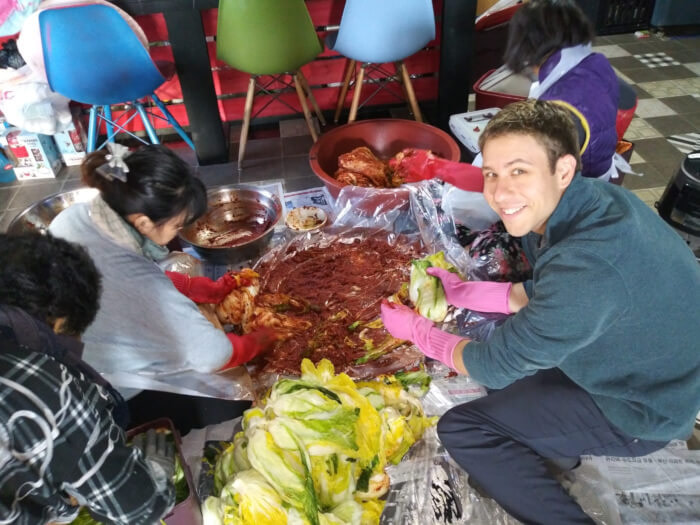 Nate making kimchi on the floor with his Korean family