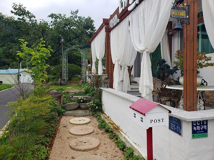 Stepping stones in front of the café with a deck and white curtains