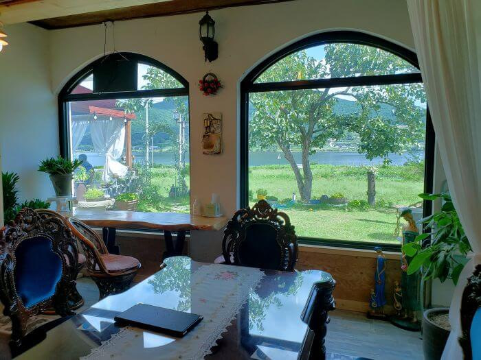 Tables inside next to windows with a view of the yard outside