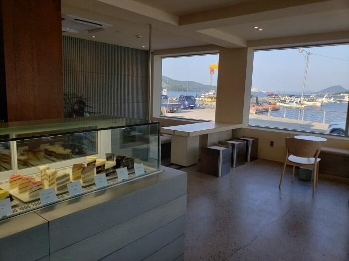 Various pieces of cake on display through the glass near the counter