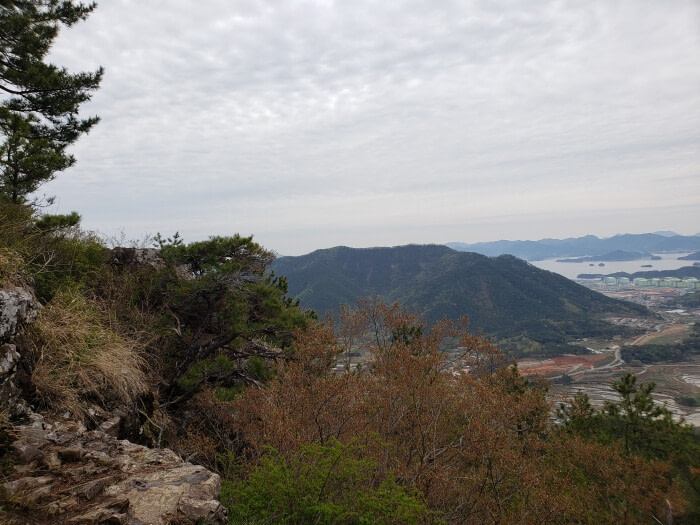 View of the sea, islands, towns, and other mountains from the first lookout area with a large rock as a platform