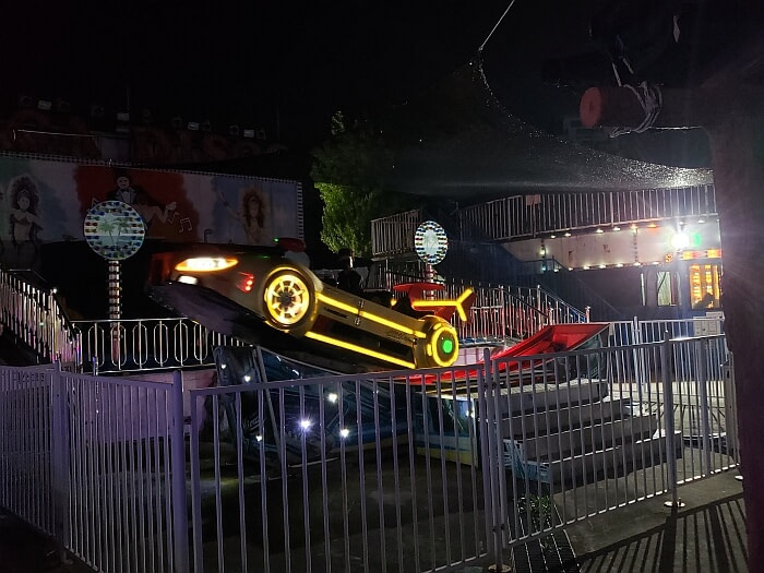 A race car ride shown with the car tilted up at and angle with yellow illuminated stripes and wheels