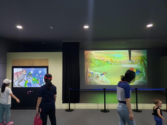 Kids moving as dinosaur characters on a screen