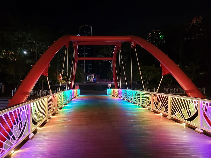 A red bridge with colorful lights at night