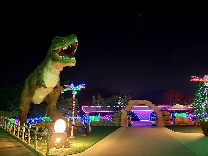 A t-rex and colorful lights at night
