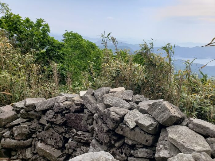 The inside of a wall of stacked rocks looking out over the sea and islands