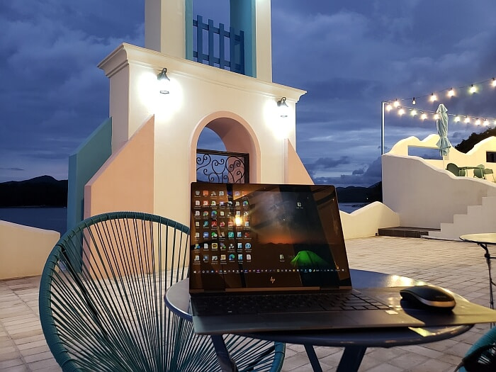 A laptop on a small table at the outdoor patio just after sunset