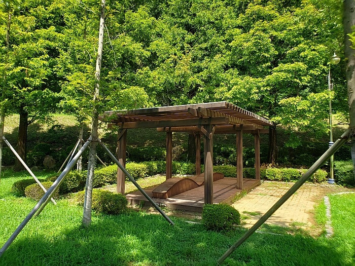 A covered wooden resting place in the corner