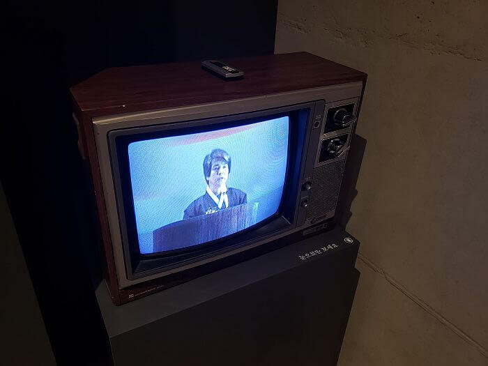 An old TV showing Jeong-gu giving a speech