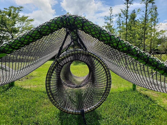 A netted tunnel under a tent-shaped net in the grass