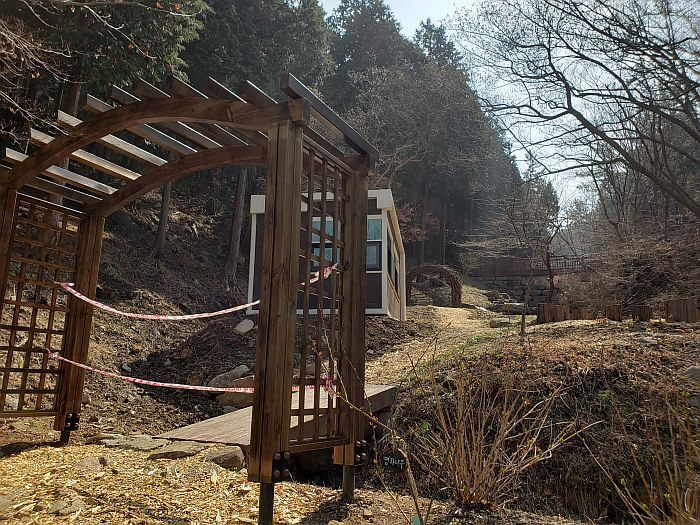 Wooden archways and a bridge scattered around a sloped area