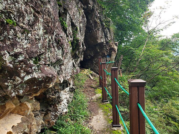 A fence along a path into a cave