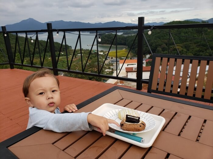 Baby Noah reaching for a cookie on a balcony