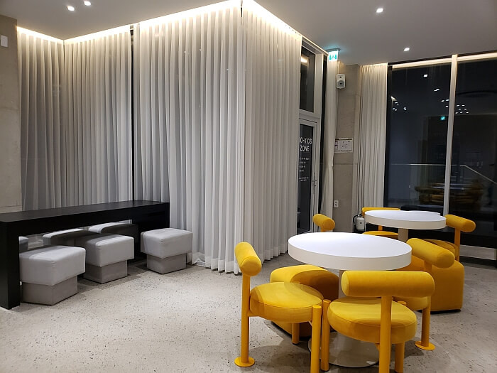 Korean café interior design orange soft chairs and drapes lit at the top