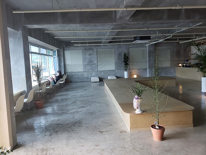 Korean café interior design concrete and row of seats along window