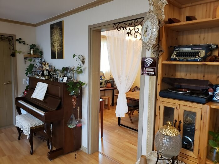 A piano and record player on a shelf with antiques