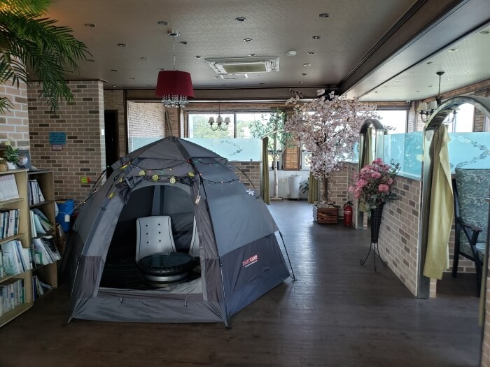 A tent inside a café across from a row of booths