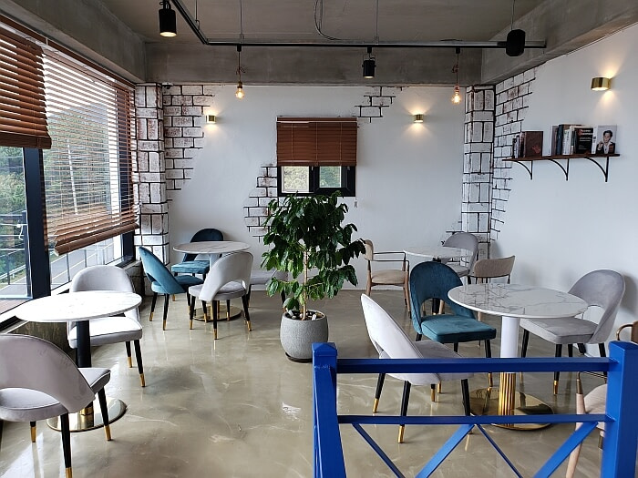 Books on a shelf on the wall on the second floor of The Wave Café
