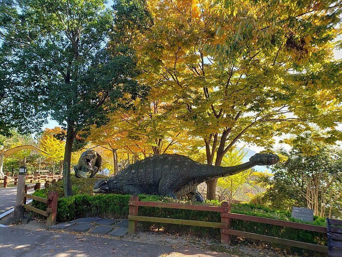 Dinosaur figures among colorful trees