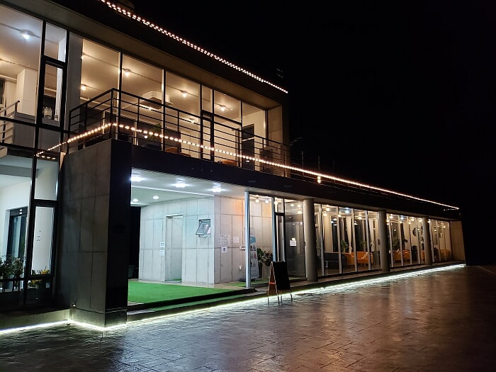 The exterior of An Café with lights at night