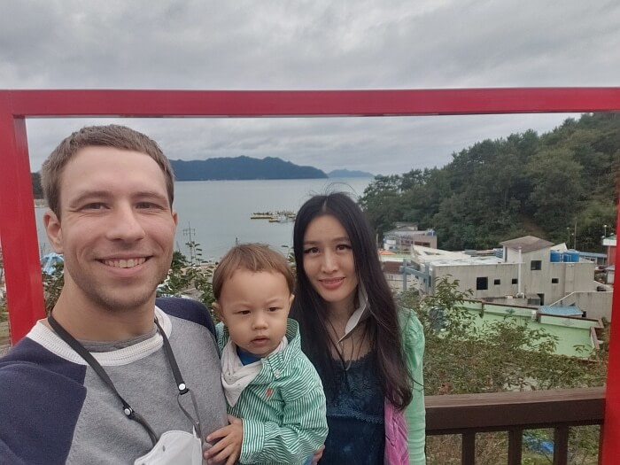 Family photo at Repos Café with red frame and view of the sea