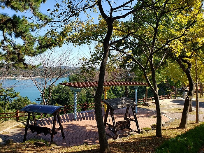 Swinging wooden benches overlooking the sea