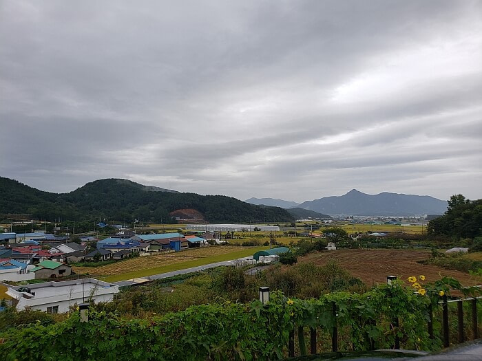 View of a village with rice fields and mountains in a cloudy day