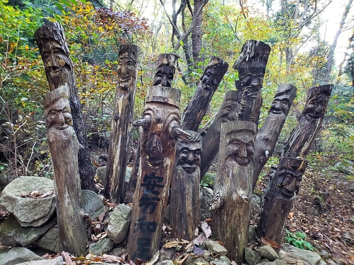 A group of wood-carved sticks sticking out of a pile of rocks in the forest