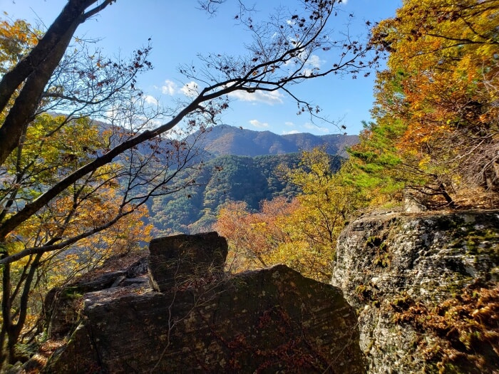 A rocky area at Yeonhwasan Provincial Park to sit down and enjoy colorful trees and a mountain view