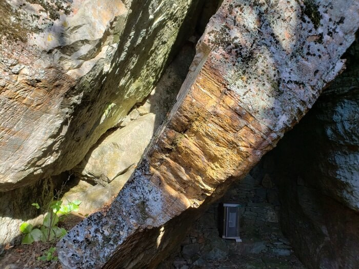 A closeup of broken rock with a metal box inside a cave