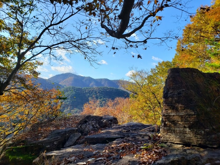 A flat, rocky area at Yeonhwasan Provincial Park with a view of colorful trees and rolling mountains