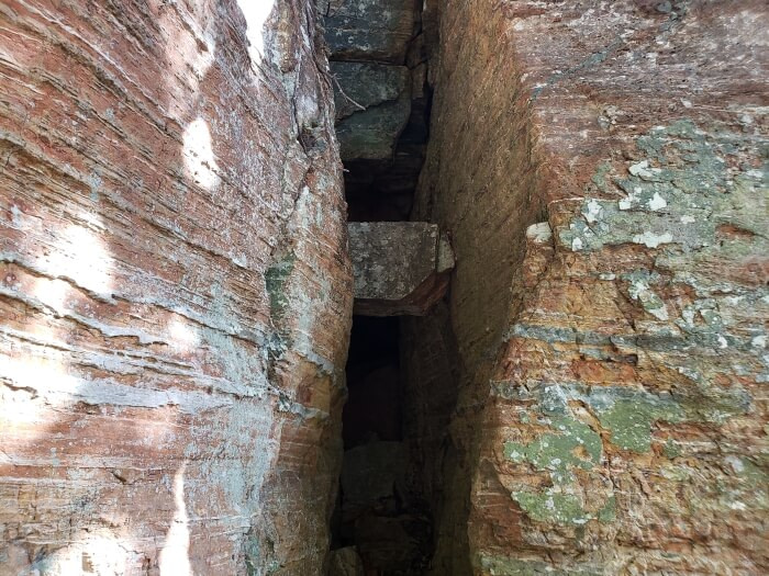 A rock stuck in a crack between two larger rocks